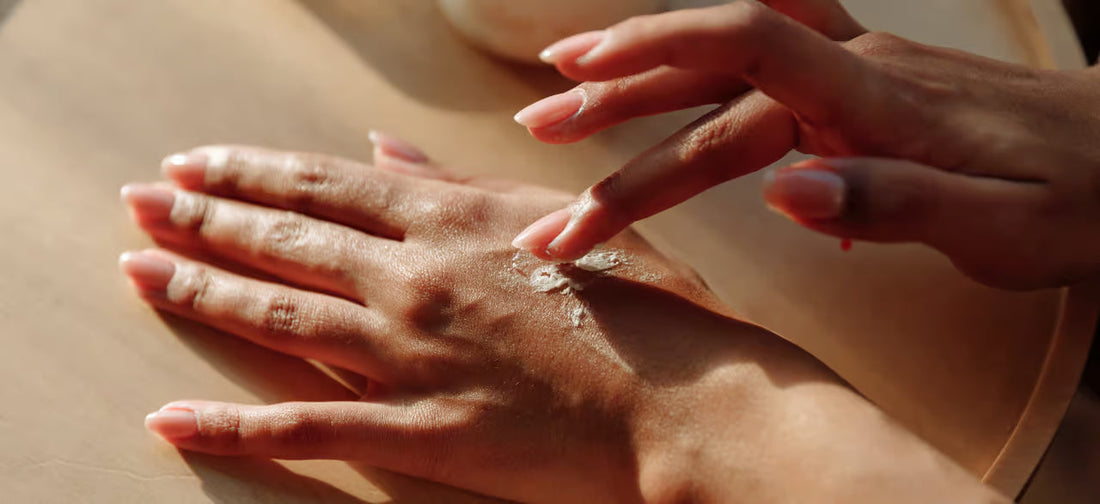 A woman with healthy nails applies a cream to her hand