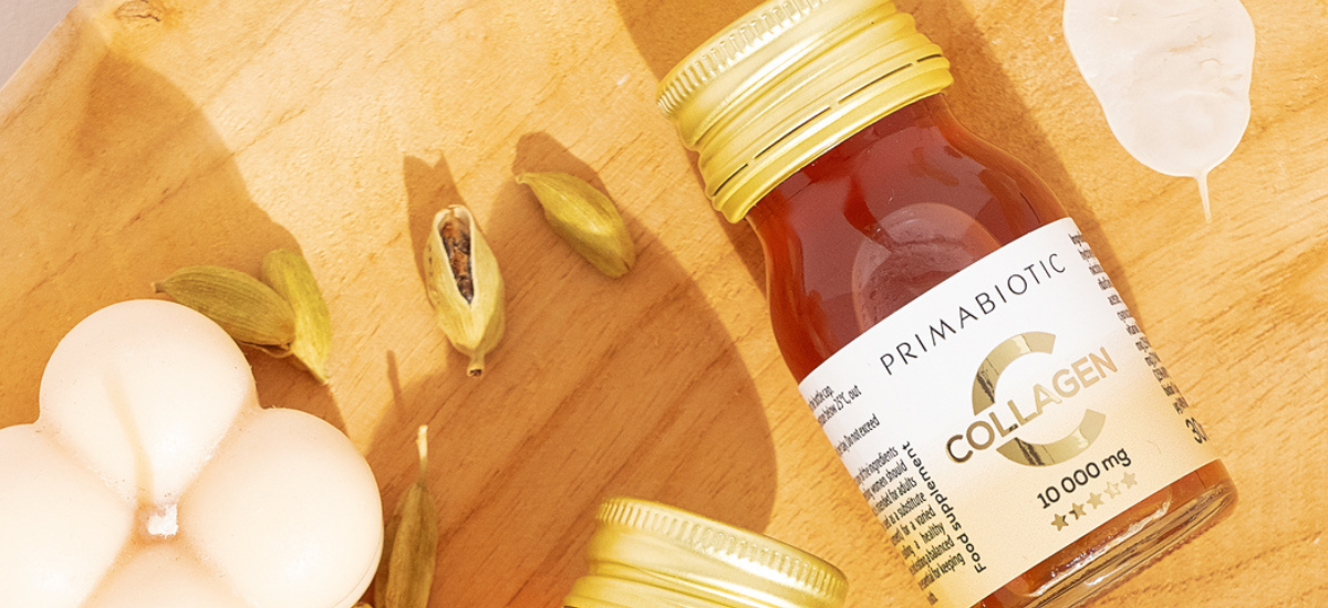 Primabiotic Collagen shot on a wooden board with cardamom and candle – natural collagen supplement for radiant skin