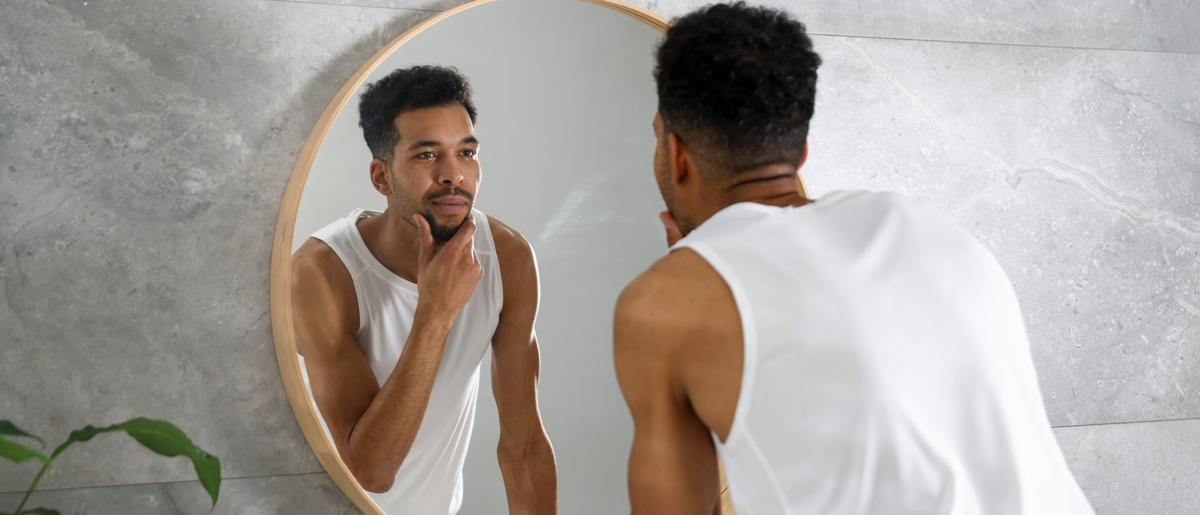 Man looking in the mirror to check the effects of using Primabiotic Collagen Shots