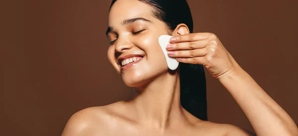 Girl massages face with gua sha stone