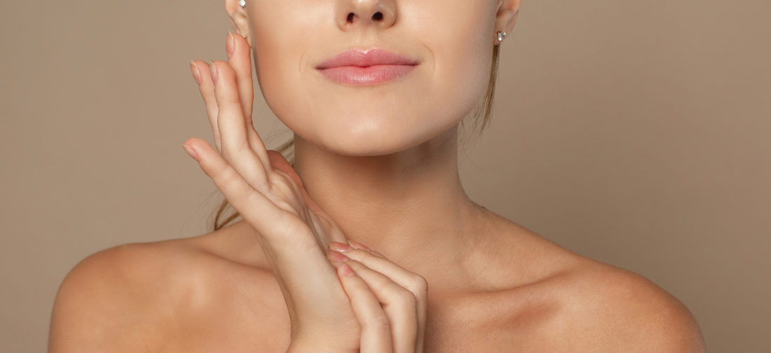 A woman with smooth and taut facial skin touches her cheek, emphasising the effect of Primabiotic collagen