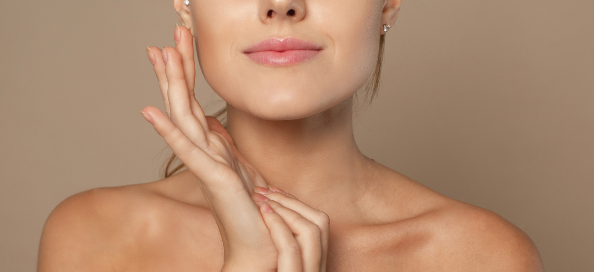 A woman with smooth and taut facial skin touches her cheek, emphasising the effect of Primabiotic collagen