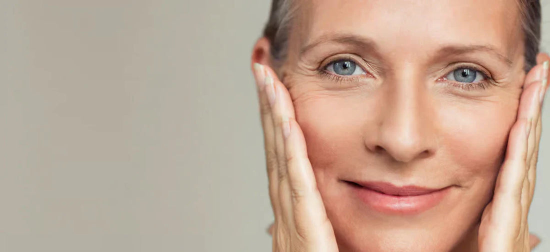 A mature woman with grey hair holds her face, showing her wrinkles before taking Primabiotic collagen shots