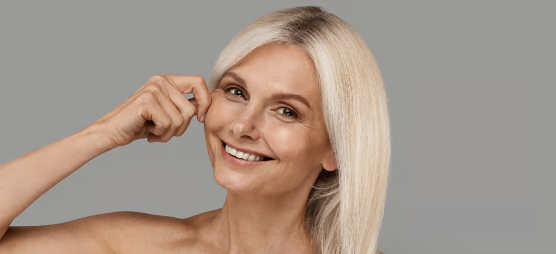 Smiling mature woman lifting her cheek to show firmness after Primabiotic collagen supplementation