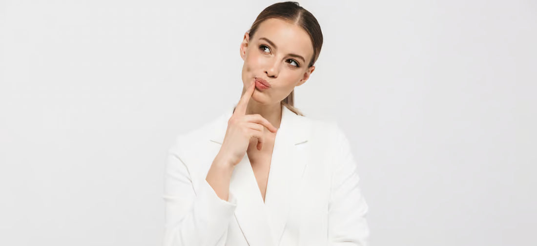 A woman in a white jacket with a thoughtful face