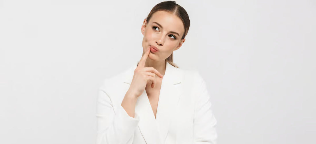 A woman in a white jacket with a thoughtful face