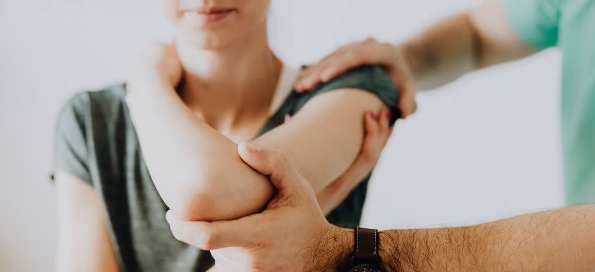 Doctor examines joint in patient's elbow