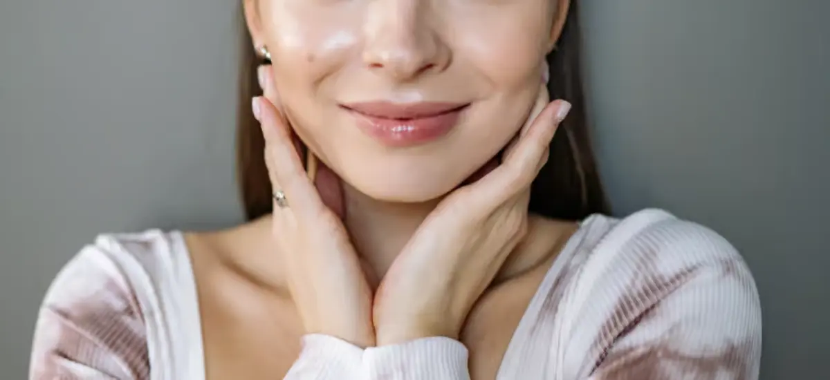 girl with glowing complexion touches her face