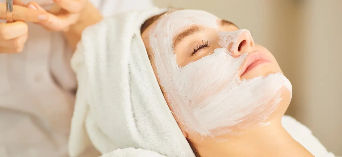 woman lies down and has a face mask applied