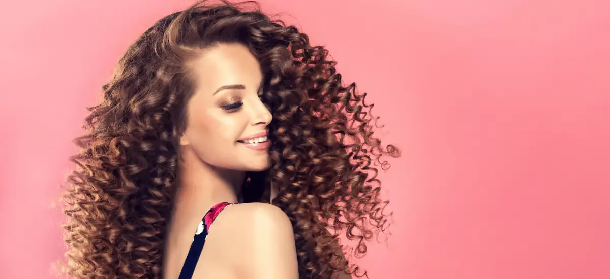 Woman with curls on a pink background